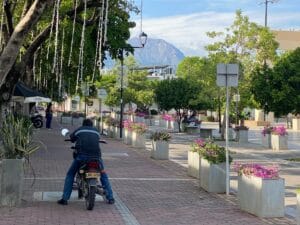 Quiet street with motorcycle and flowers. Valledupar, Colombia.